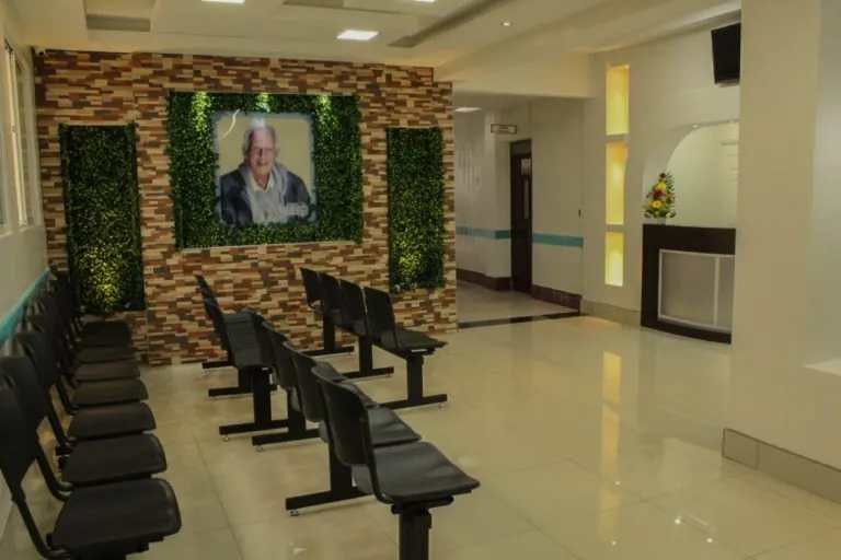 Sala de espera con una pared de piedra y un retrato enmarcado
